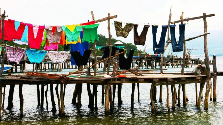 Person hand-washing durable fabric clothing in soapy water, demonstrating garment care and maintenance