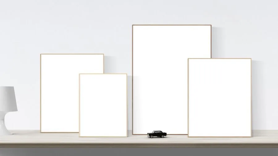 Person hanging and arranging multiple photo frames on a white wall in home interior