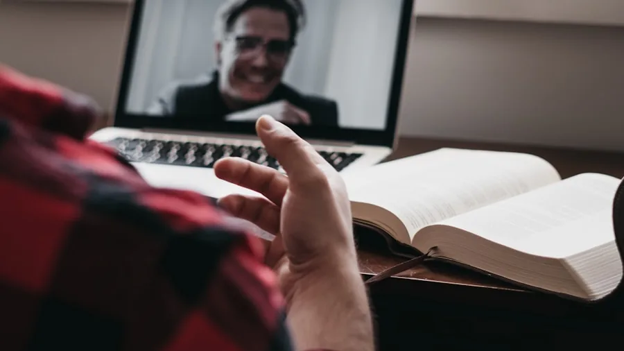 Person having video conference on laptop during work from home, speaking clearly into microphone