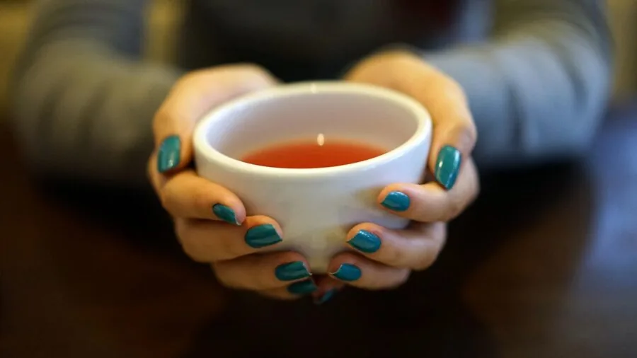 Person holding a warm mug with comfortable grip and relaxed hand position