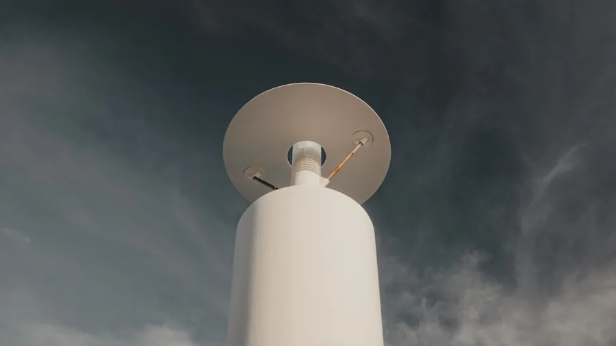 Person holding anemometer measuring wind speed outdoors in natural daylight
