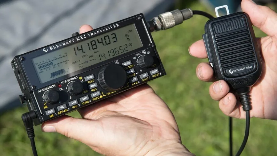 Person holding compact emergency radio in jacket pocket during outdoor situation