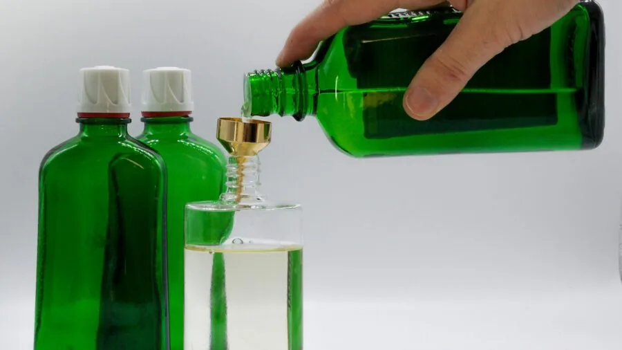 Person holding eco-friendly refillable bottles in natural light, comparing product sizes and sustainability