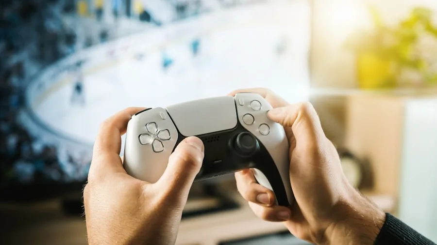 Person holding game controller while playing video game on television in living room