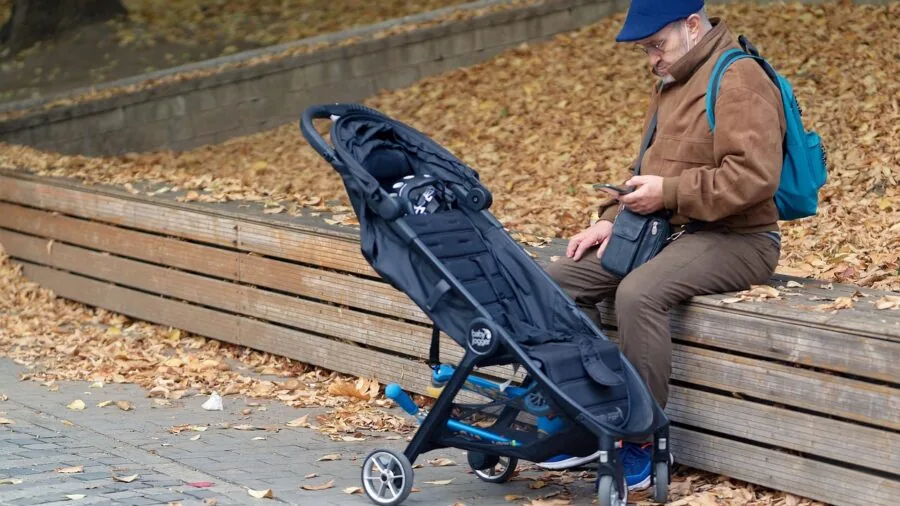 Person holding smartphone in landscape orientation watching video content with kickstand support