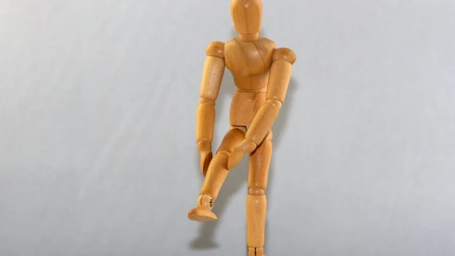 Person holding their knee in pain while sitting, illustrating targeted pain relief needs