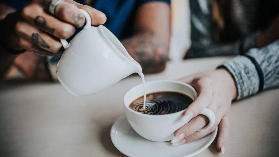 Person holding warm ceramic mug during morning coffee moment, lifestyle scene
