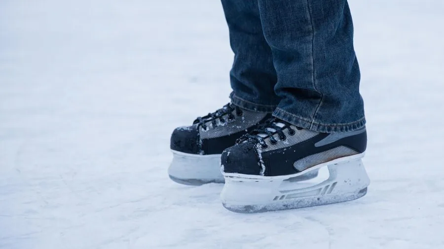 Person ice skating outdoors on frozen lake during winter, demonstrating recreational skating in natural setting