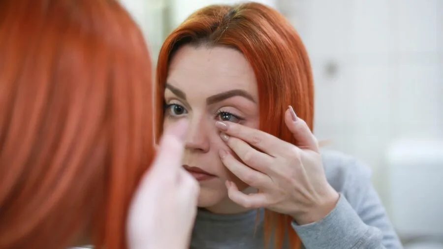 Person in bathroom preparing for self-care routine, focusing on personal wellness and hygiene practices