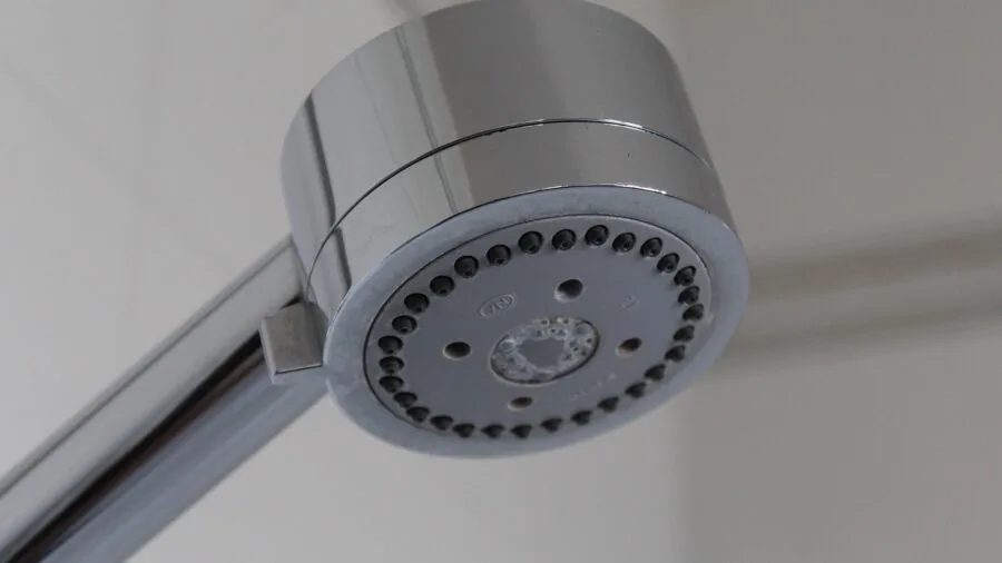 Person in bathroom shower demonstrating waterproof protection and dry hair care during bathing