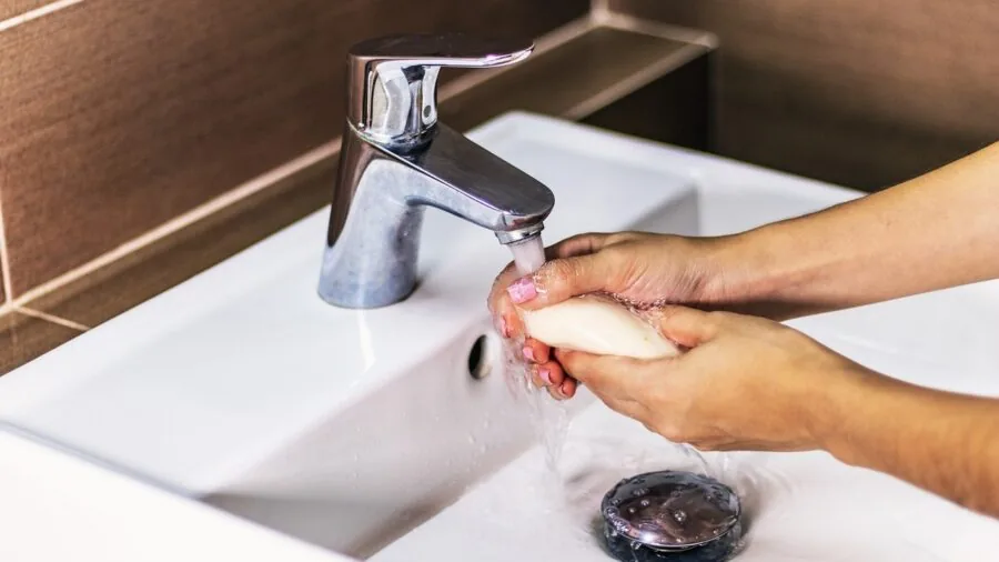 Person in modern bathroom setting focusing on personal hygiene and wellness care