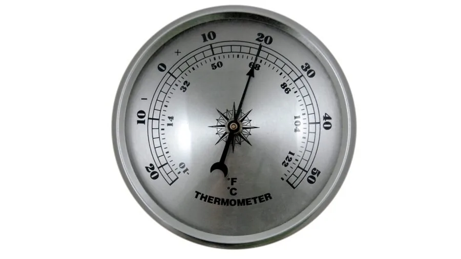 Person in sleeping bag checking temperature gauge during cold camping night in wilderness