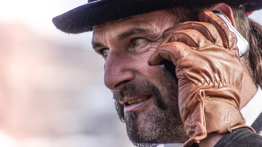 Person in winter gloves interacting with smartphone touchscreen outdoors in cold weather