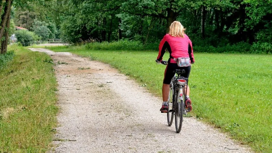 Person inline skating on a smooth paved bike path through a natural outdoor setting