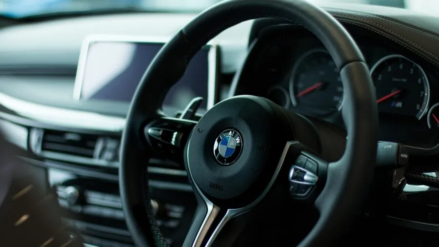 Person inserting USB charger into car dashboard socket while driving
