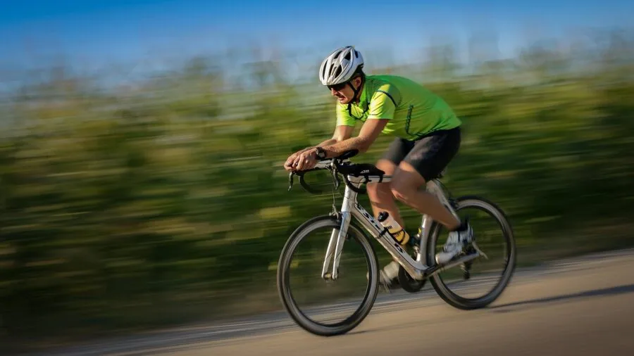 Person inspecting bicycle wheel and tire compatibility outdoors