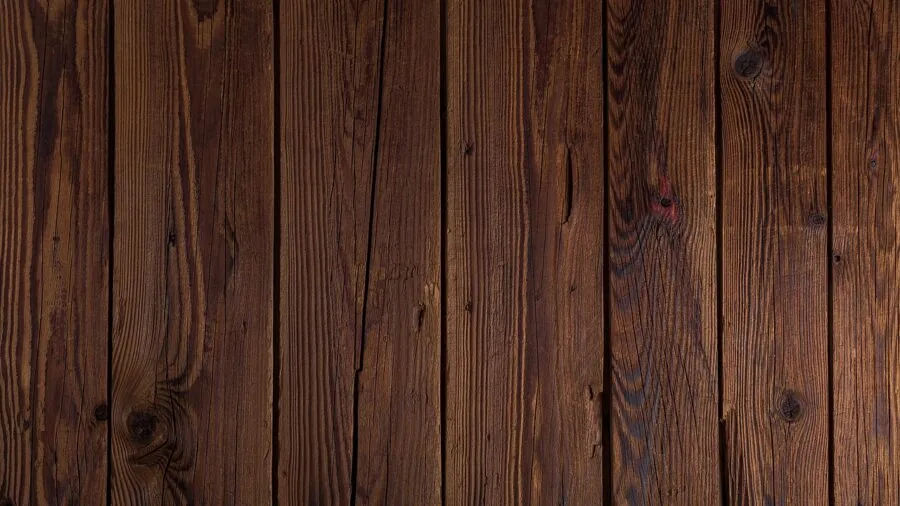 Person inspecting fine wood grain and quality craftsmanship in natural daylight