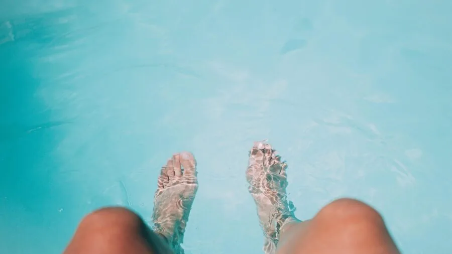 Person inspecting their feet during a warm foot soak bath at home
