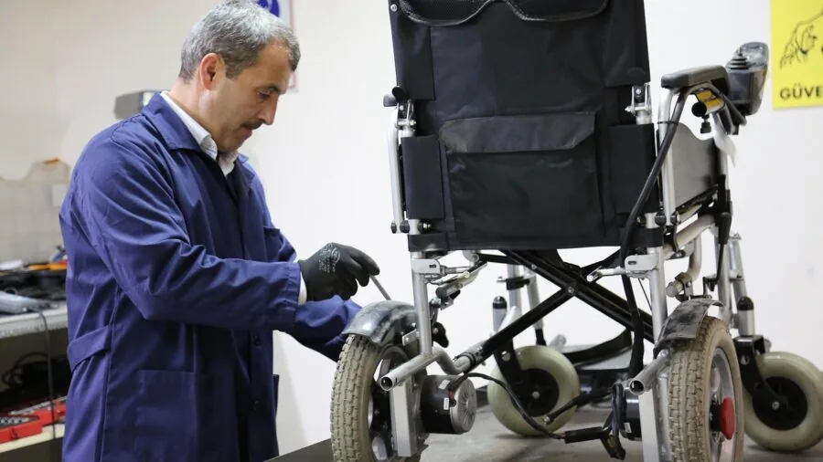 Person inspecting truck wheel and undercarriage during vehicle maintenance check