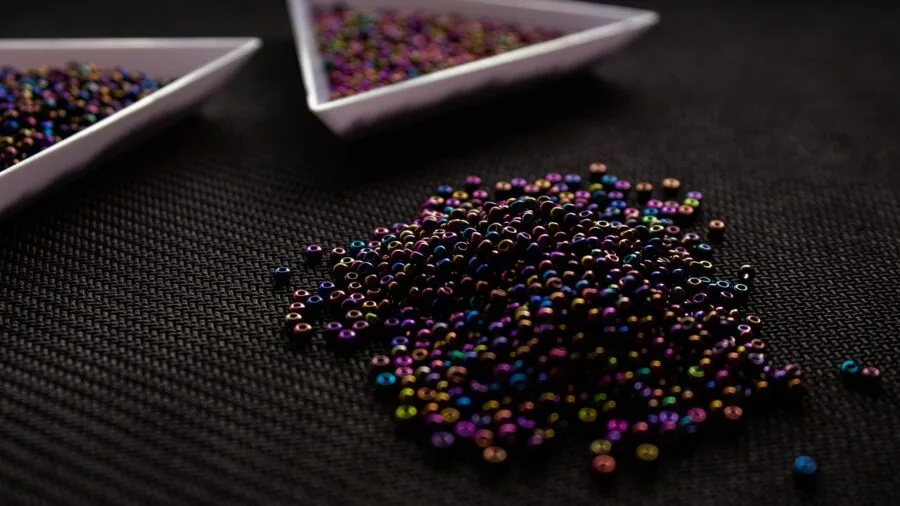 Person inspecting various dice materials and textures up close on wooden surface