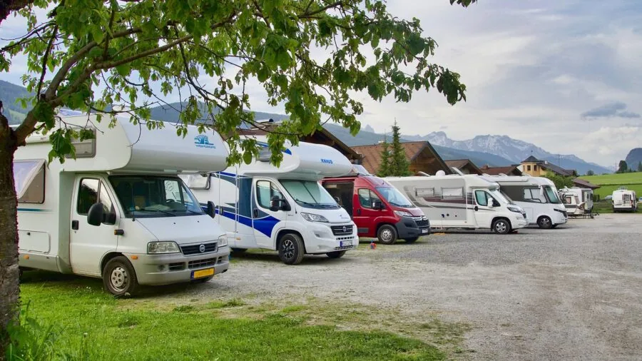 Person installing weatherproof vent cover on recreational vehicle roof during maintenance work