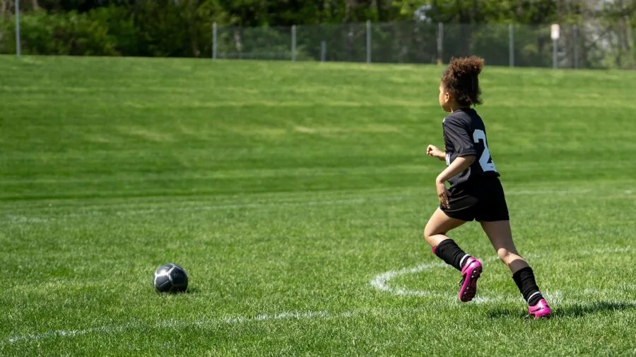 Person jogging outdoors with focused posture demonstrating stable, controlled movement during exercise