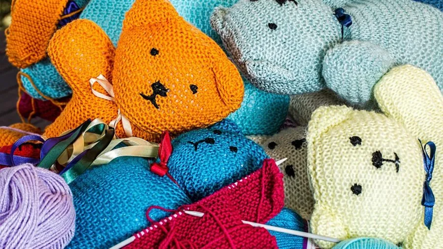 Person knitting with different yarn thicknesses showing texture variety in natural lighting