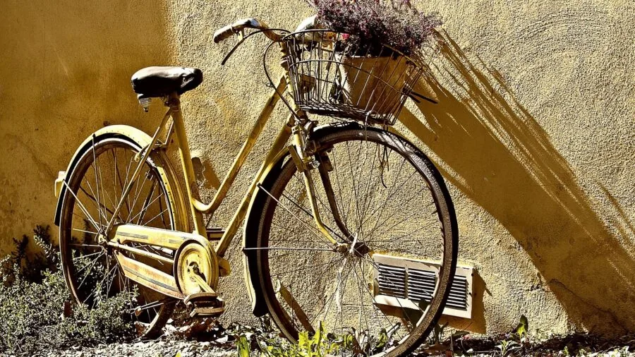 Person lifting and carrying a lightweight folding bike up interior staircase in natural light