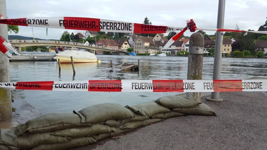 Person lifting and positioning sandbag for flood protection barrier construction