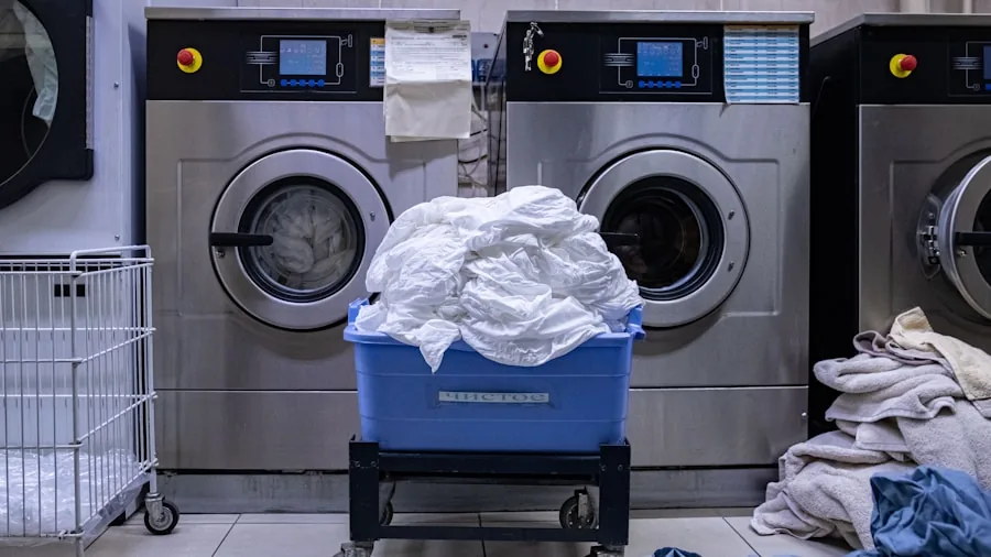 Person loading blankets into a washing machine during laundry day at home