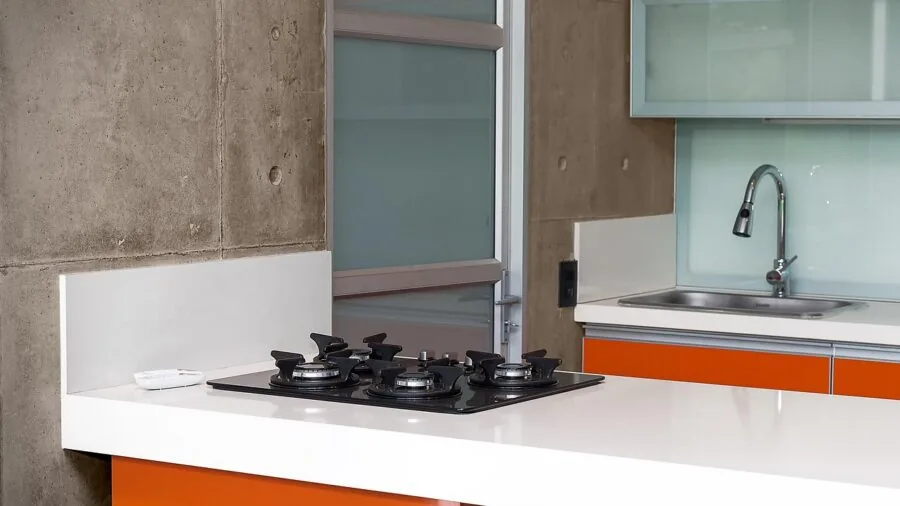 Person loading clean dinner plates into an open dishwasher in a contemporary kitchen setting
