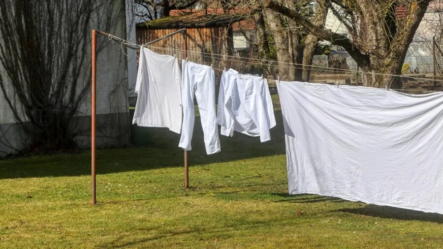 Person loading colorful clothes into a washing machine during laundry day