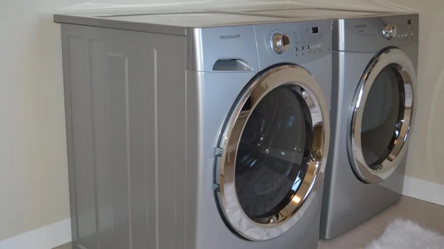 Person loading colorful clothes into a washing machine for laundry day