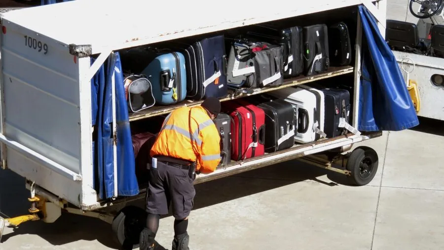 Person locking a suitcase at airport check-in counter before domestic flight