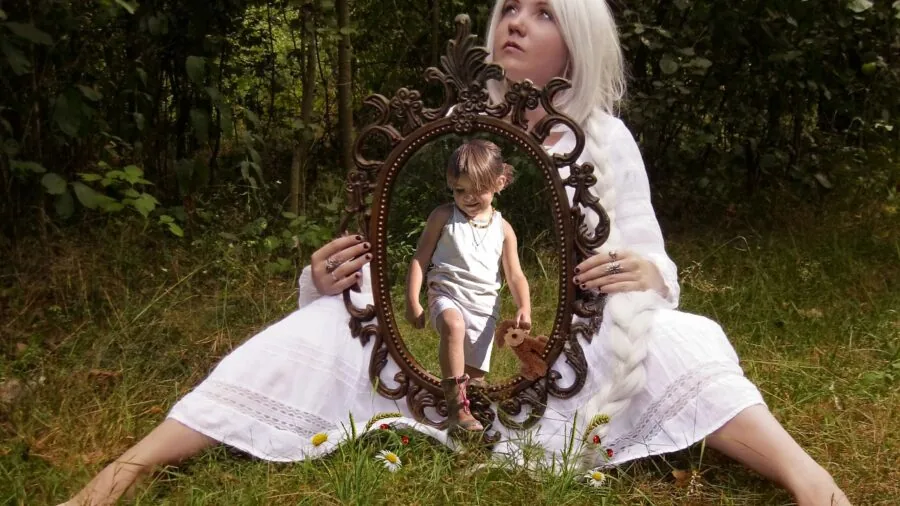 Person looking at their smile in bathroom mirror, checking teeth whiteness and dental health
