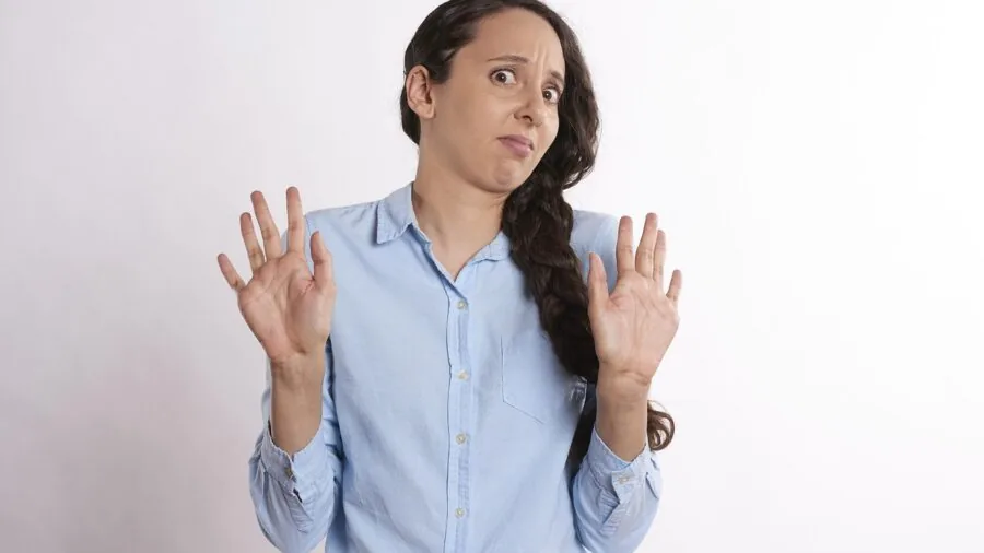 Person looking frustrated while assembling fitness equipment with scattered tools and instruction manual