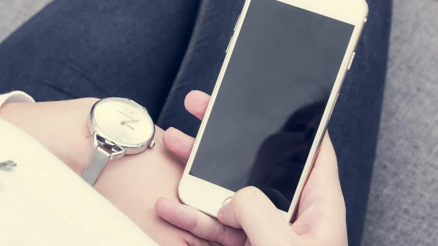 Person looking frustrated while using smartphone app on mobile device, representing app usability challenges