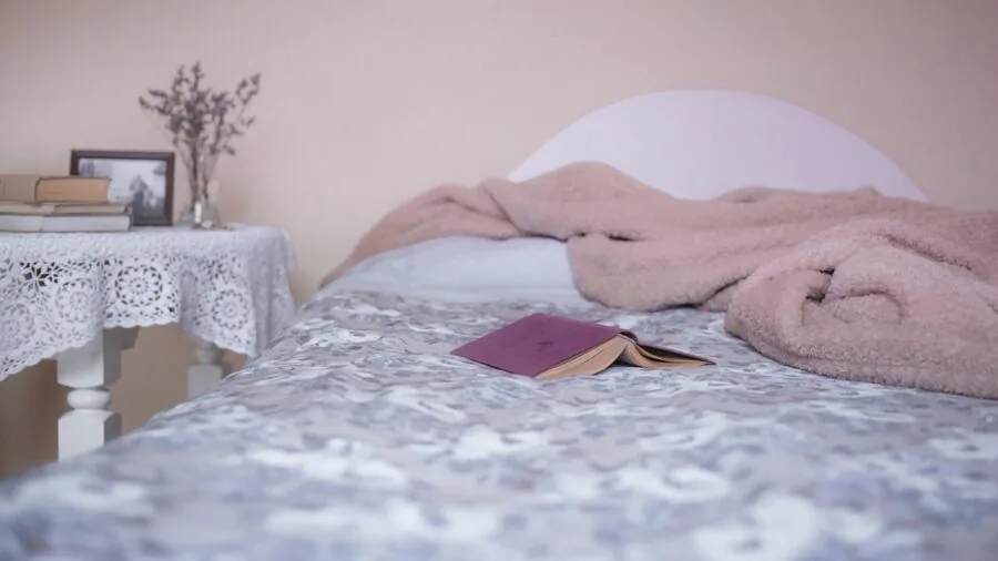 Person lying in bed covered with a weighted blanket, showing proper coverage and comfort