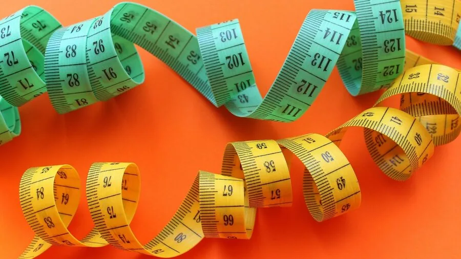 Person measuring extension cord length for residential use and storage capacity planning