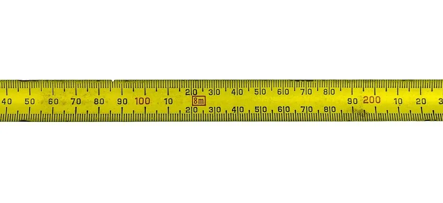 Person measuring kitchen cabinet interior dimensions with tape measure before organizing