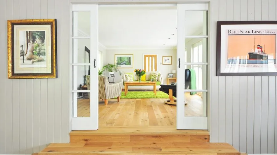 Person measuring living room space with tape measure before furniture delivery