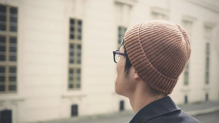 Person modeling various beanie styles showing cuffed, slouchy, and fitted options in casual lifestyle setting