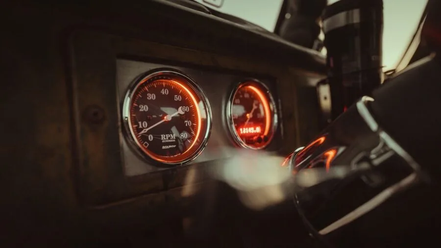 Person monitoring car dashboard while driving on highway, checking vehicle performance indicators