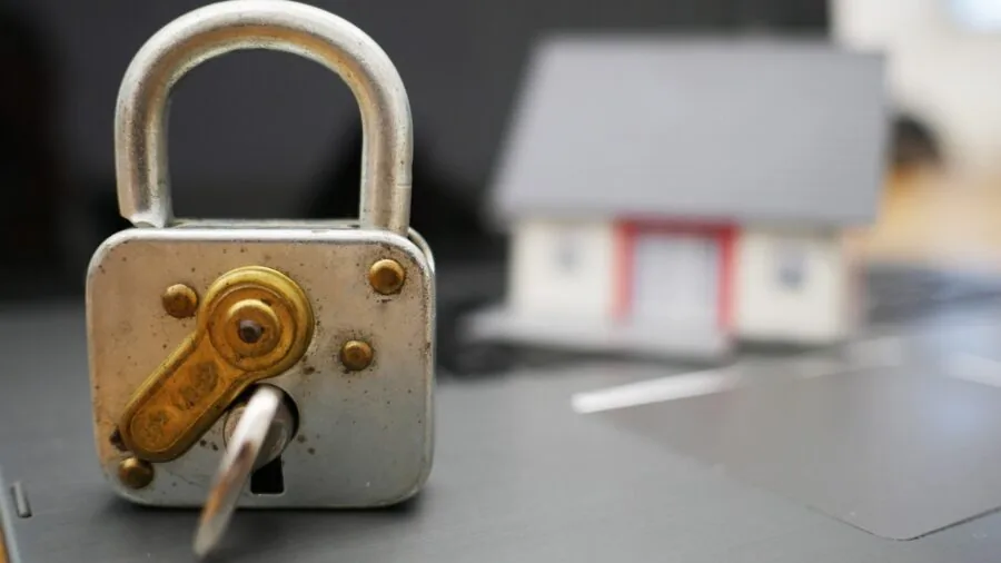 Person monitoring home security system at night with dark exterior view on screen
