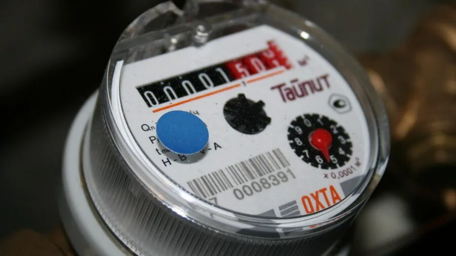 Person monitoring humidity levels on a digital meter in a workshop setting