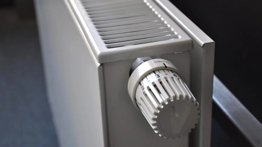 Person monitoring temperature dial on heating equipment in workshop setting