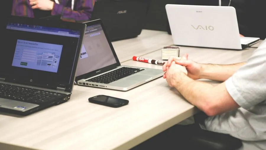 Person multitasking at desk with multiple monitors and creative work displayed