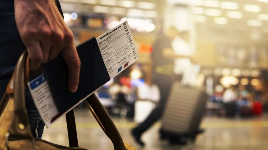 Person navigating airport terminal with rolling luggage, focusing on smooth wheel movement and maneuverability during travel.