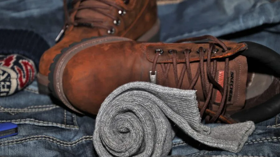 Person neatly organizing clothes and items inside an open suitcase for travel