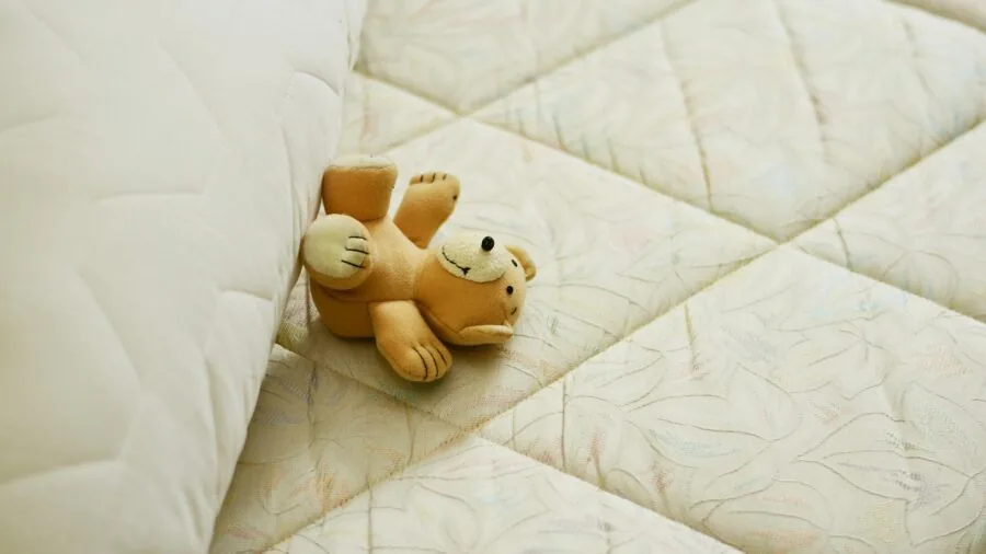 Person opening a compressed mattress box in a bedroom, examining the new bedding product